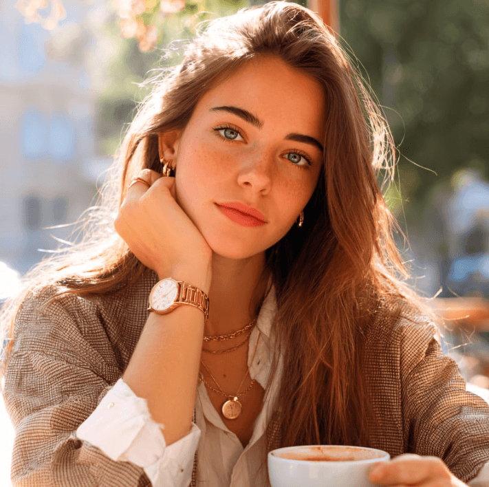 Young woman enjoying coffee in a cozy café, showcasing a relaxed and stylish demeanor.